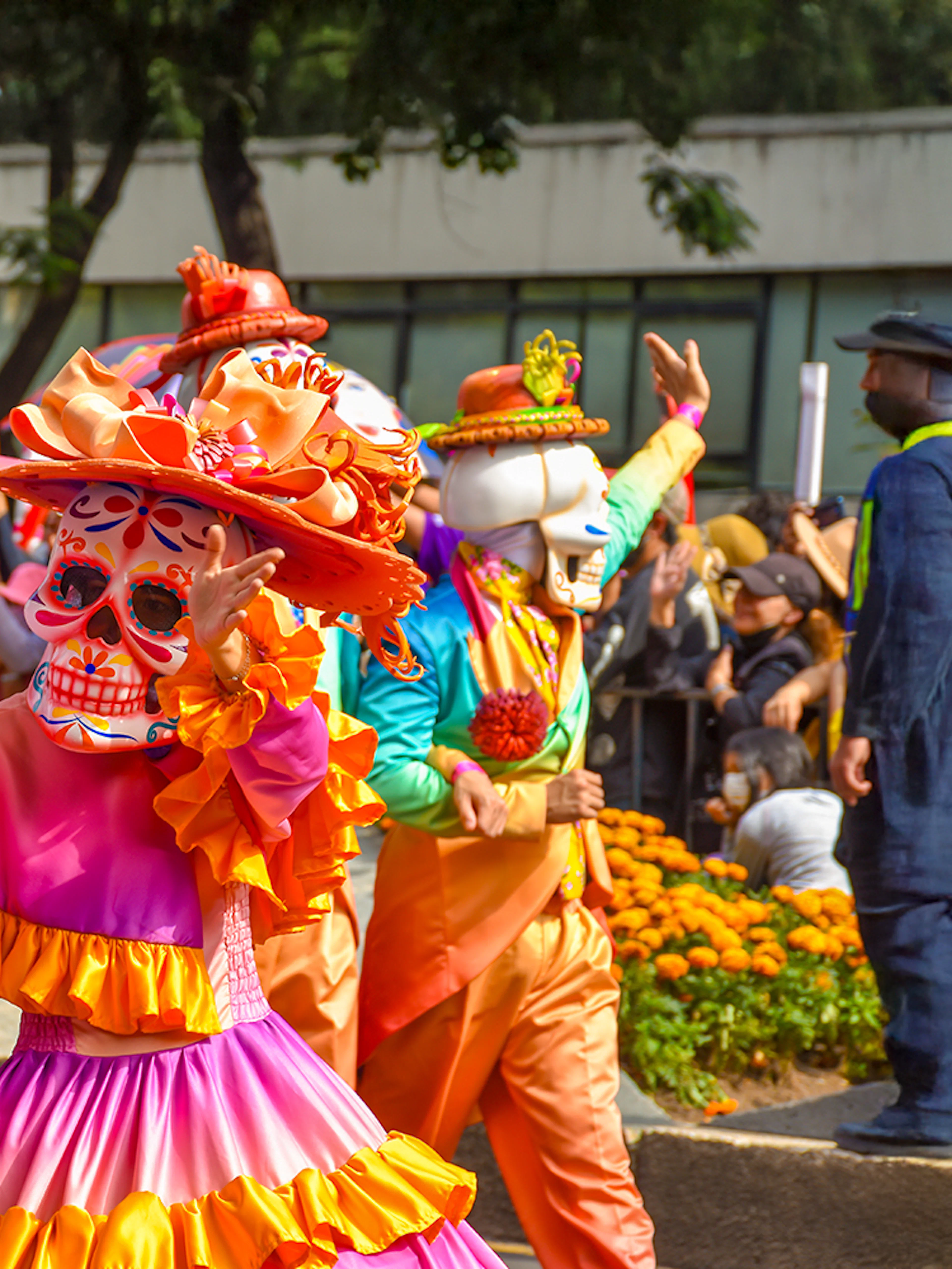 Participants in colorful costumes and skull masks at Day of the Dead parade, Mexico.