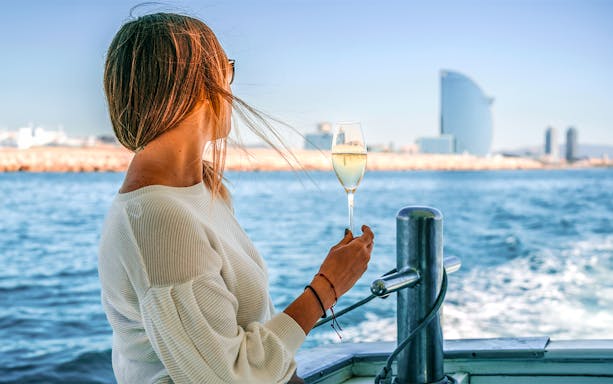 Woman enjoying a boat ride with a view of Barcelona's coastline and W Hotel.