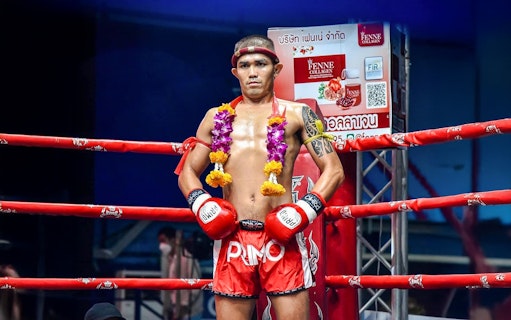Muay Thai fighter in the ring at Rawai Muay Thai Boxing Camp, wearing traditional garlands.