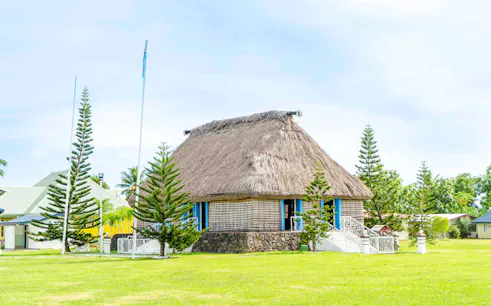 Traditional Fijian bure with thatched roof in Nadi, surrounded by lush greenery.