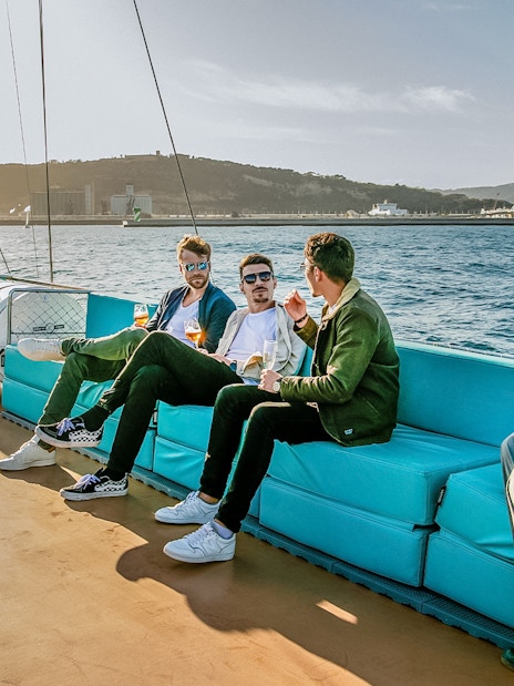 Tourists relaxing on a cruise in Barcelona with city skyline in the background.