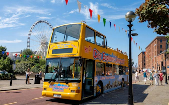 City Explorer Liverpool bus near Ferris wheel on Mersey sightseeing tour.