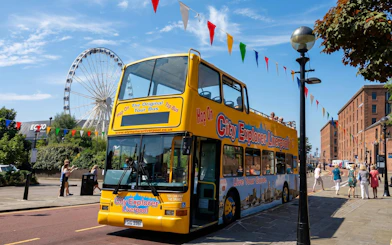 City Explorer Liverpool bus near Ferris wheel on Mersey sightseeing tour.