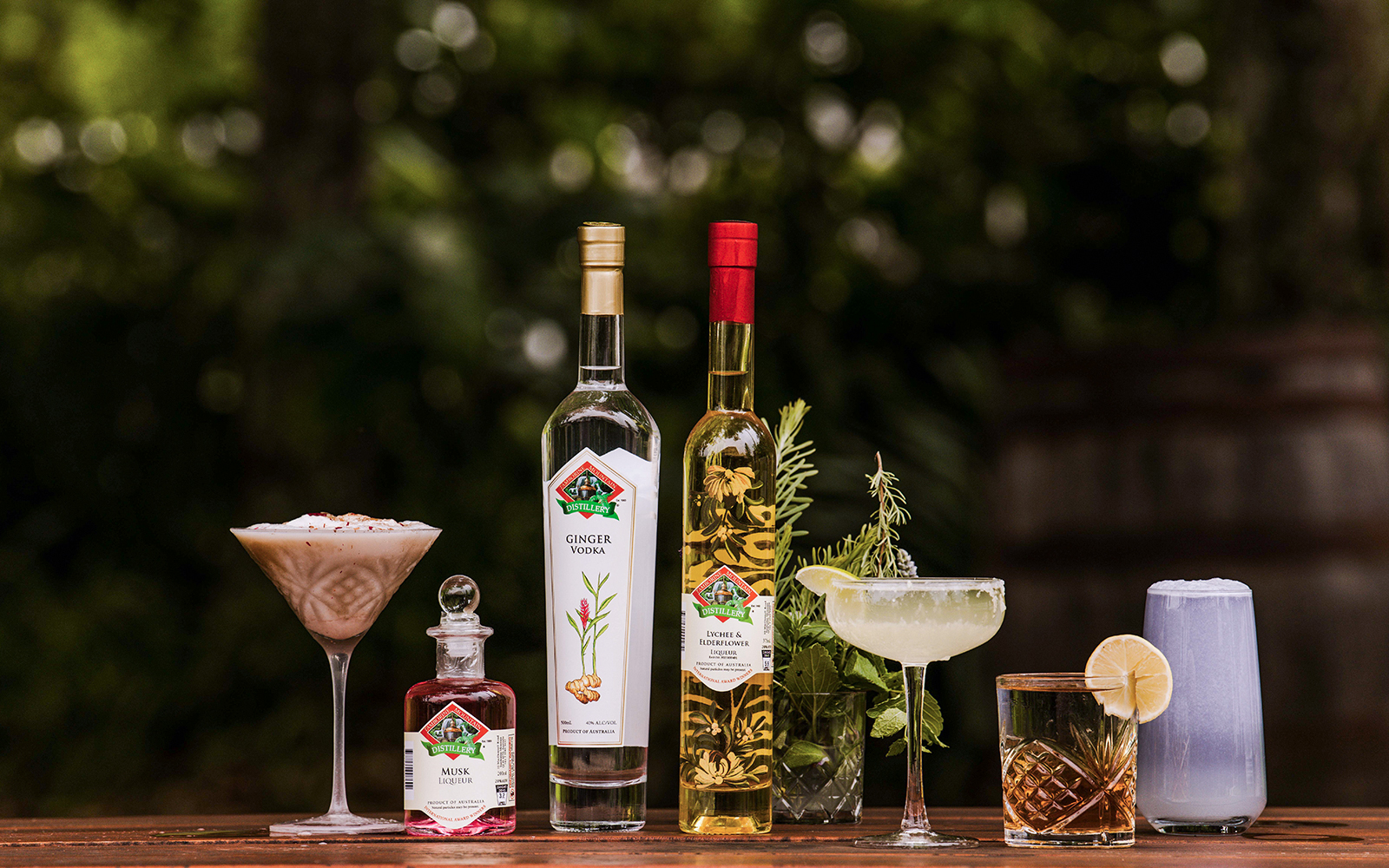 Assorted drinks and spirits from Tamborine Mountain distillery on a wooden table.