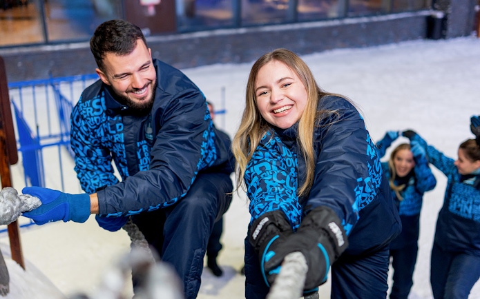 Couple climbing rope wall at Sky Dubai Snow Park.
