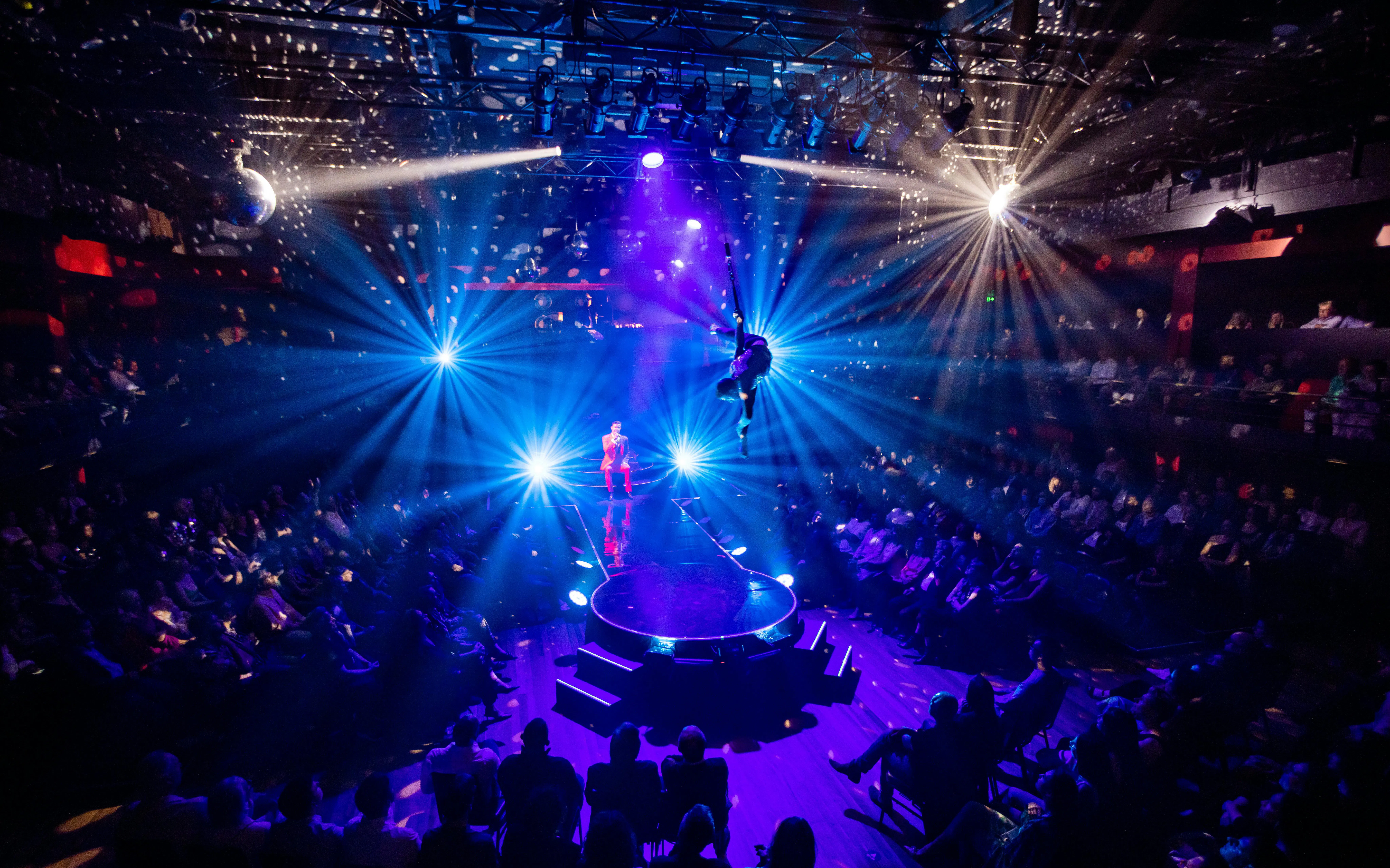 Aerial performer at Velvet Inferno show in Sydney with vibrant stage lighting.