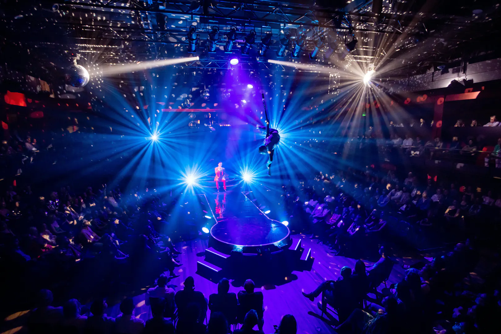 Aerial performer at Velvet Inferno show in Sydney with vibrant stage lighting.