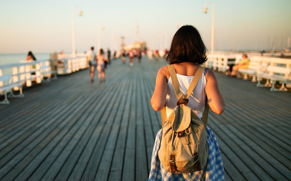 Traveler walking on a Sopot pier at sunset in Gdansk, Poland.