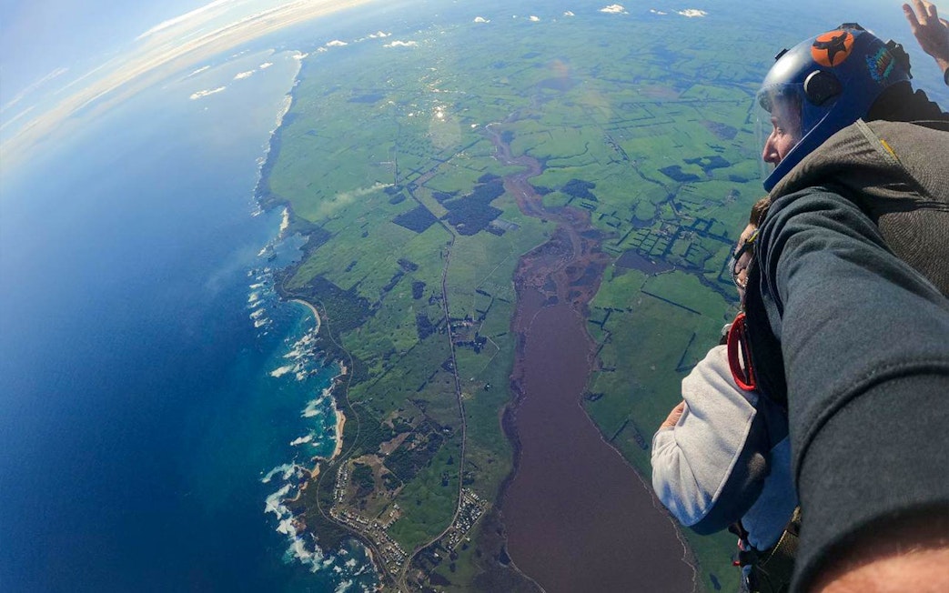 Tandem skydive view over Great Ocean Road, 12 Apostles region, showing coastline and farmland.