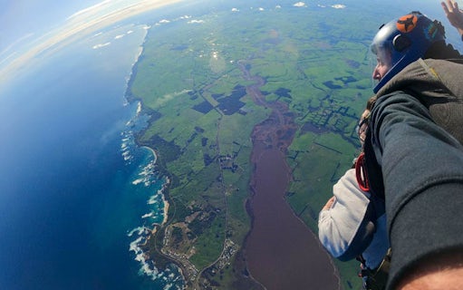 Tandem skydive view over Great Ocean Road, 12 Apostles region, showing coastline and farmland.
