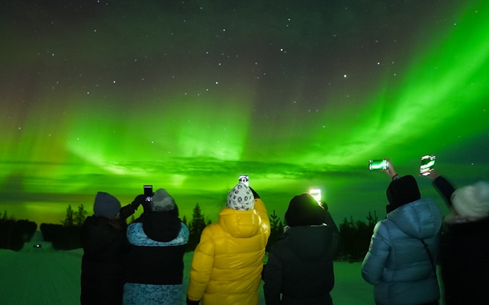Small group watching Northern Lights in Levi, Finland.
