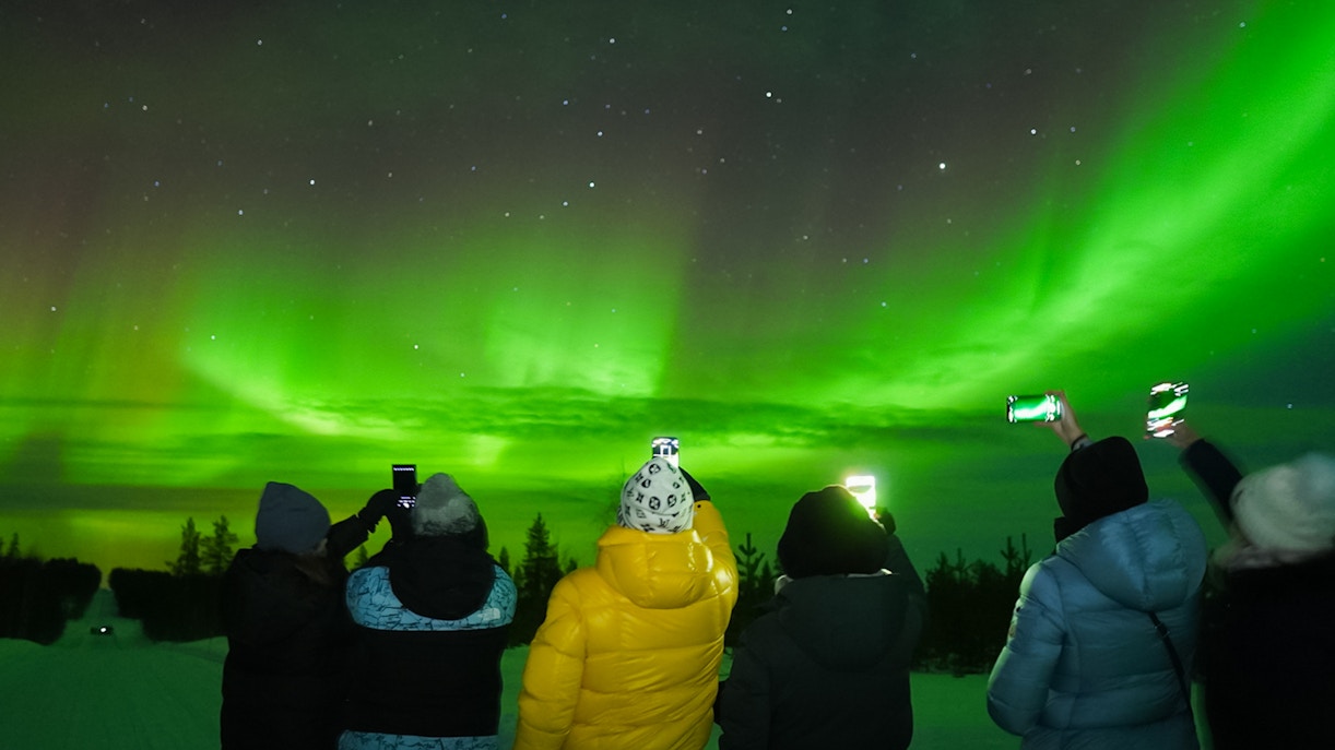 Small group watching Northern Lights in Levi, Finland.