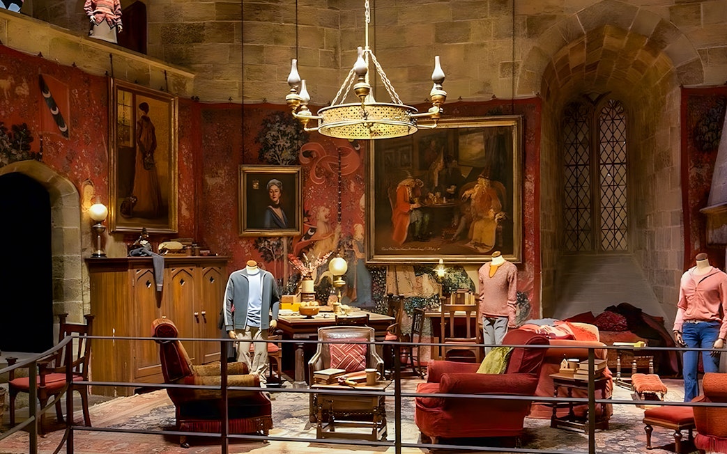 Gryffindor common room exhibit at Harry Potter London tour with costumes and decor.