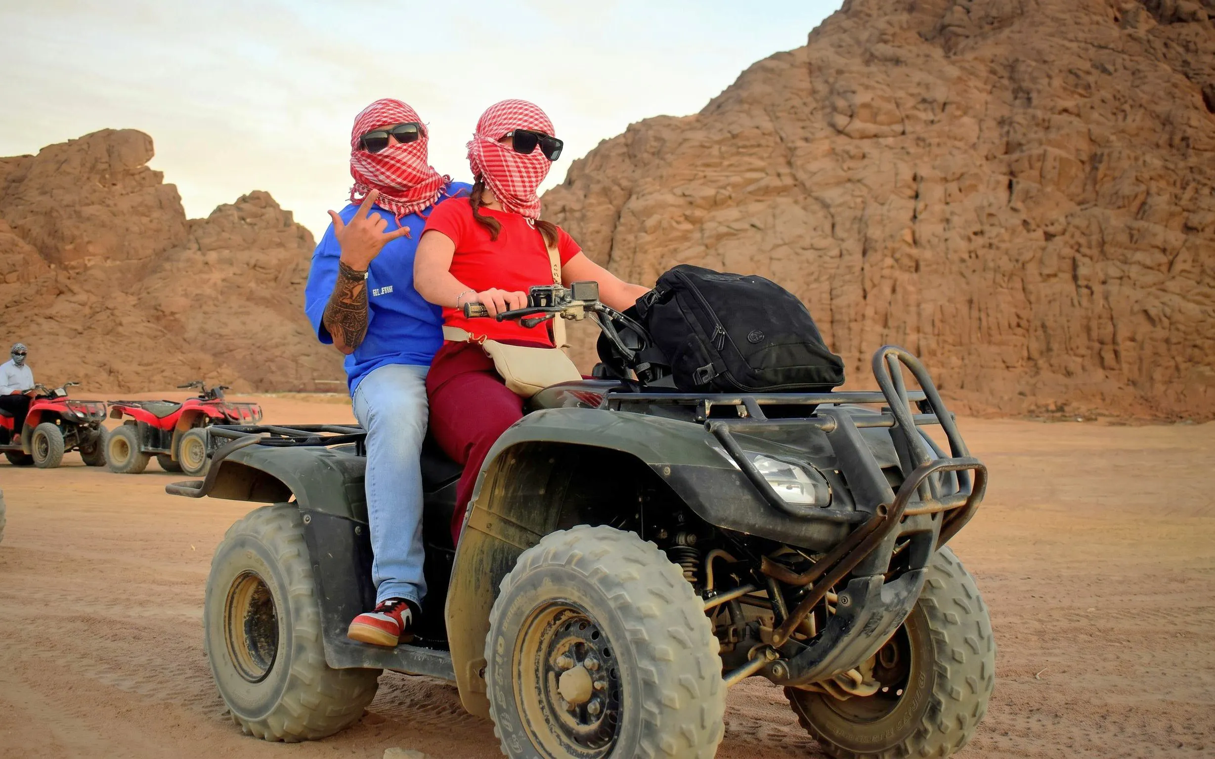 Quad biking in Sinai Desert, Sharm El Sheikh, with rocky landscape in background.