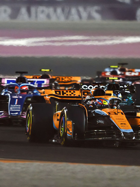 Race cars competing in the F1 Qatar Grand Prix.