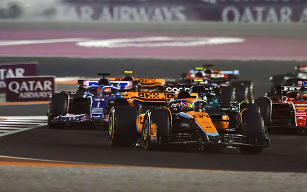 Race cars competing in the F1 Qatar Grand Prix.