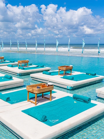Sun loungers by the pool at Atlas Beach Club with ocean view.