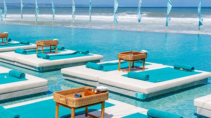 Sun loungers by the pool at Atlas Beach Club with ocean view.