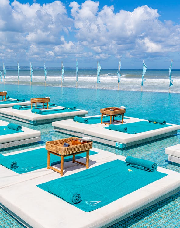 Sun loungers by the pool at Atlas Beach Club with ocean view.