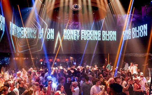 DJ performing at Club Chinois with crowd enjoying the music.