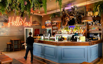 Riverhead Tavern interior with bar counter and neon sign during scenic boat cruise.