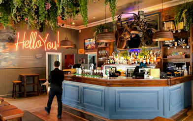 Riverhead Tavern interior with bar counter and neon sign during scenic boat cruise.