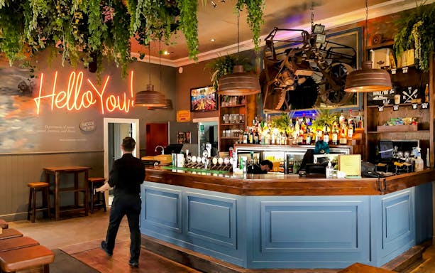 Riverhead Tavern interior with bar counter and neon sign during scenic boat cruise.