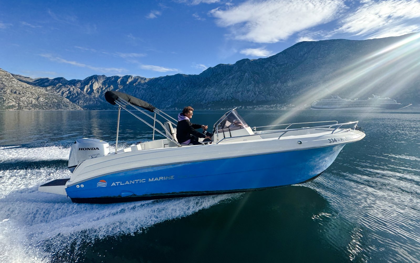 Speedboat cruising near mountains during Perast & Our Lady of the Rocks tour.