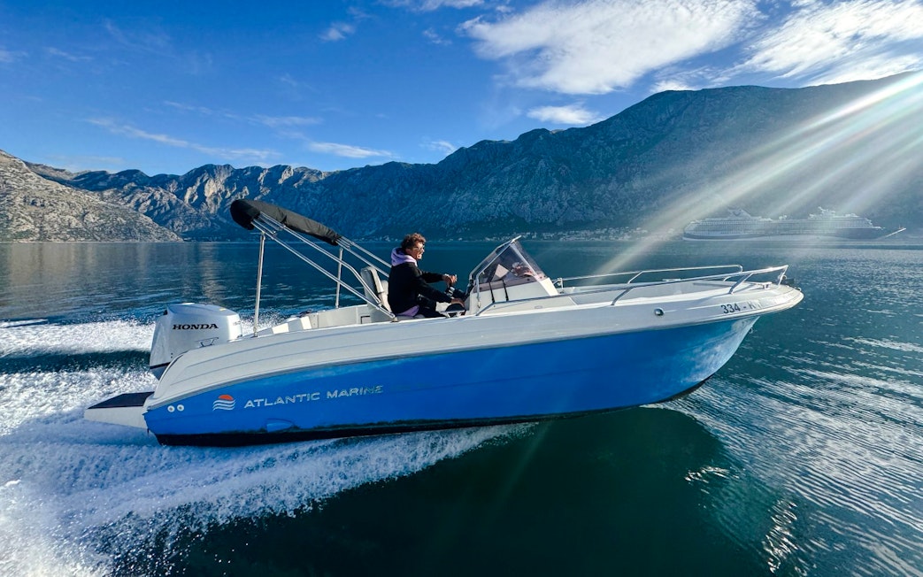 Speedboat cruising near mountains during Perast & Our Lady of the Rocks tour.