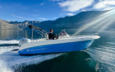 Speedboat cruising near mountains during Perast & Our Lady of the Rocks tour.