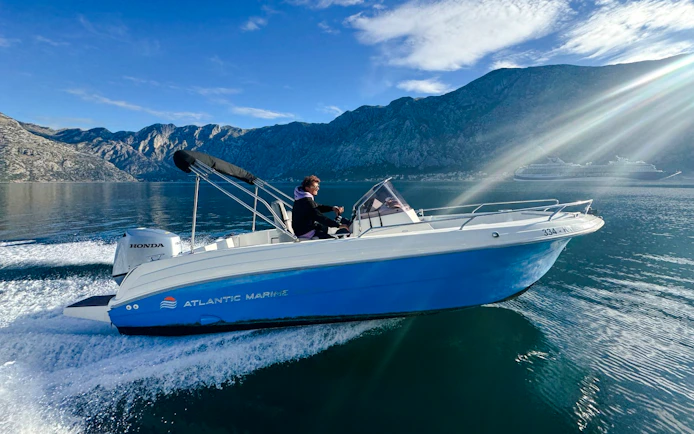 Speedboat cruising near mountains during Perast & Our Lady of the Rocks tour.