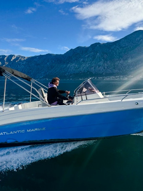 Speedboat cruising near mountains during Perast & Our Lady of the Rocks tour.