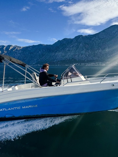 Speedboat cruising near mountains during Perast & Our Lady of the Rocks tour.