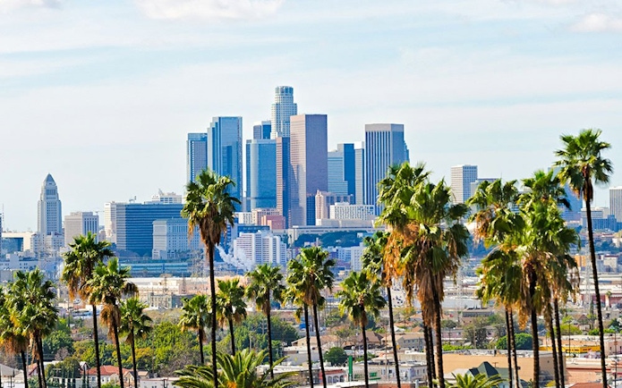 Skyline of Los Angeles with palm trees along Santa Monica Boulevard.