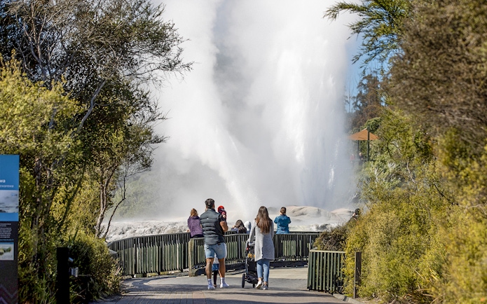 Visitors watching a geyser erupt at Te Puia, Rotorua, during the Te Rā Guided Experience.