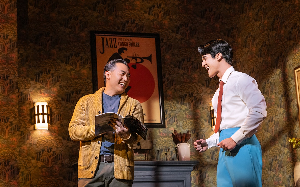 Two actors smiling and interacting on stage during "Maybe Happy Ending" performance.