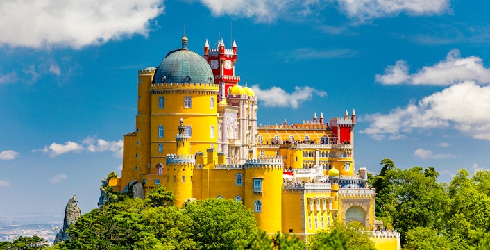 Pena Palace in Sintra, Portugal, with colorful towers and lush surrounding park.