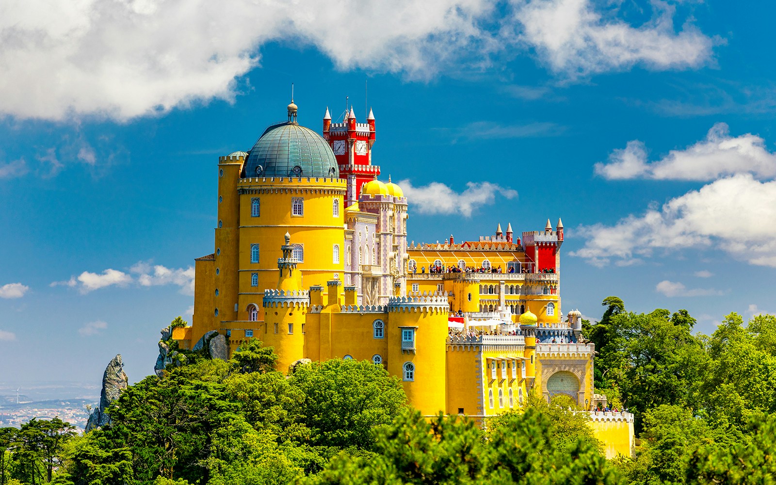 Pena Palace in Sintra, Portugal, with colorful towers and lush surrounding park.