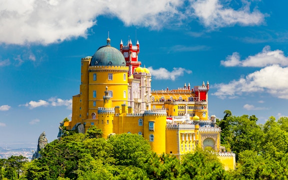 Pena Palace in Sintra, Portugal, with colorful towers and lush surrounding park.