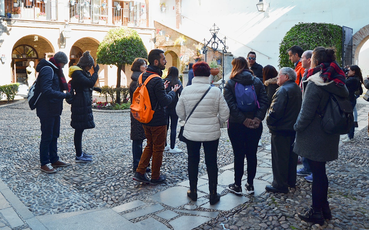 Visitors on a guided tour in the courtyard of Cordoba Mosque-Cathedral and Jewish Quarter.
