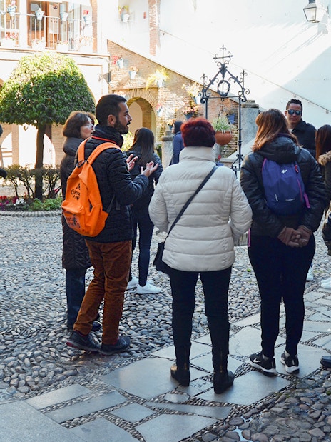 Visitors on a guided tour in the courtyard of Cordoba Mosque-Cathedral and Jewish Quarter.