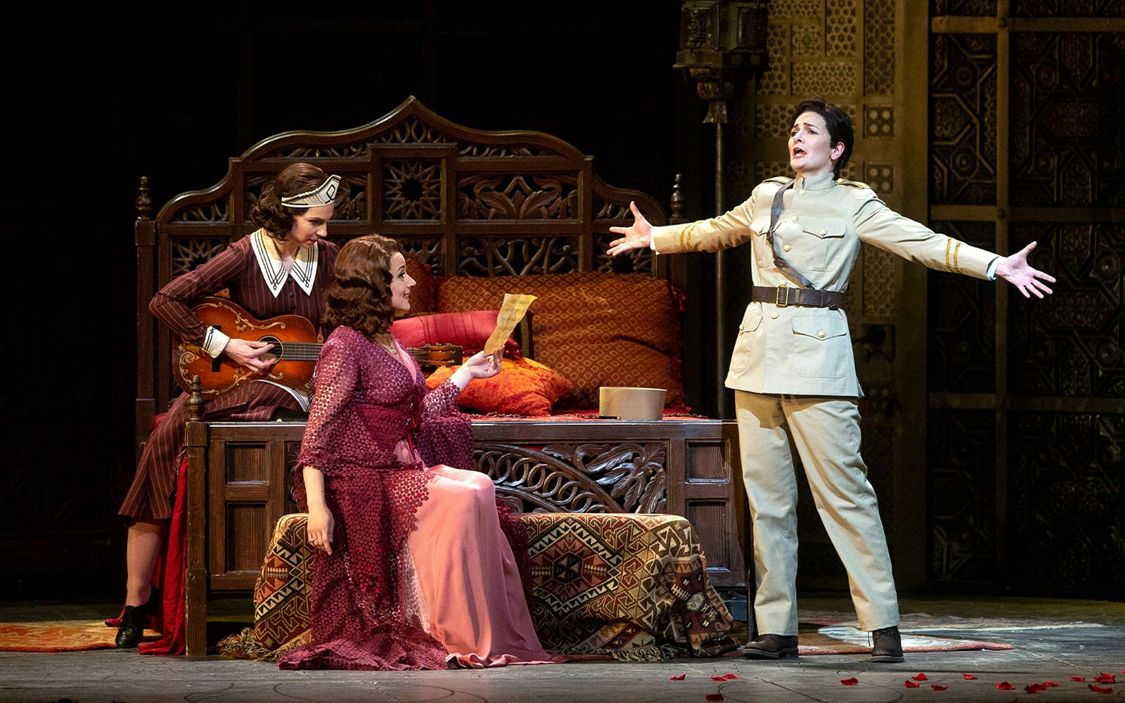 Opera performers in a scene from Le Nozze Di Figaro, with one holding a letter.