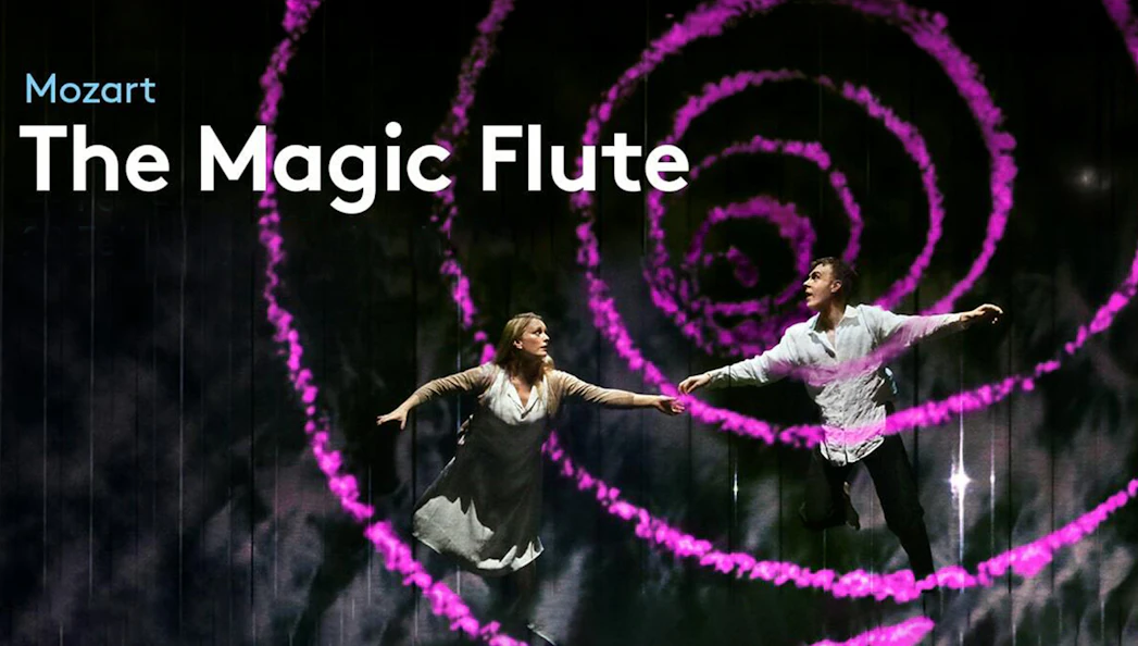 Performers on stage during "The Magic Flute" with swirling pink lights.