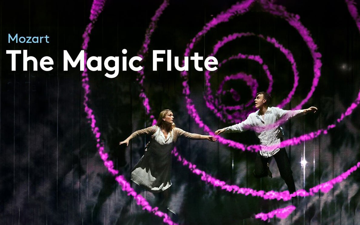 Performers on stage during "The Magic Flute" with swirling pink lights.