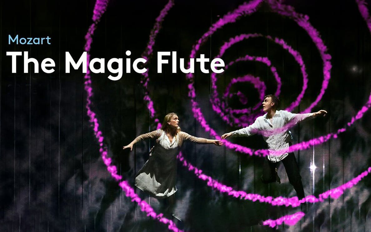 Performers on stage during "The Magic Flute" with swirling pink lights.