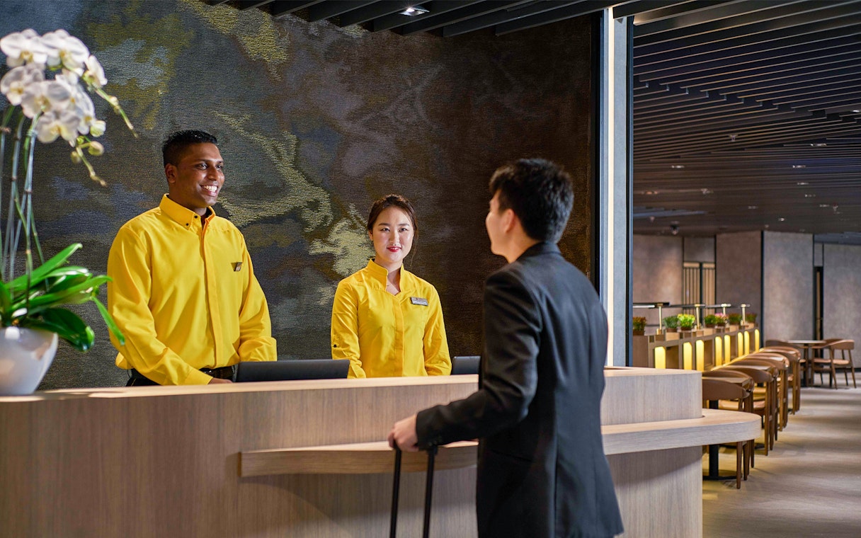 Reception staff assisting a traveler at Plaza Premium Lounge, KLIA Terminal 2.
