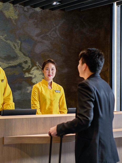 Reception staff assisting a traveler at Plaza Premium Lounge, KLIA Terminal 2.
