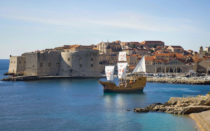 Sailing ship near Dubrovnik's historic city walls on Elaphite Islands cruise.