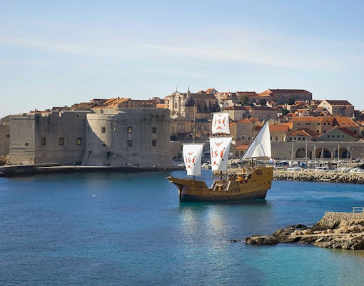 Sailing ship near Dubrovnik's historic city walls on Elaphite Islands cruise.