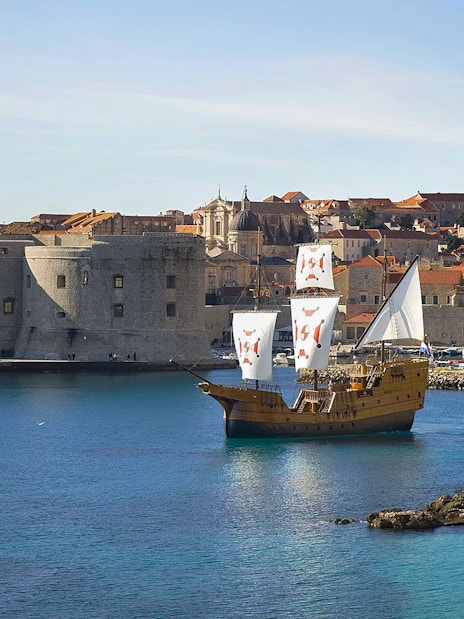 Sailing ship near Dubrovnik's historic city walls on Elaphite Islands cruise.